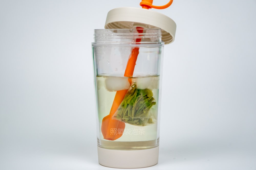 a cup filled with liquid and vegetables inside of it