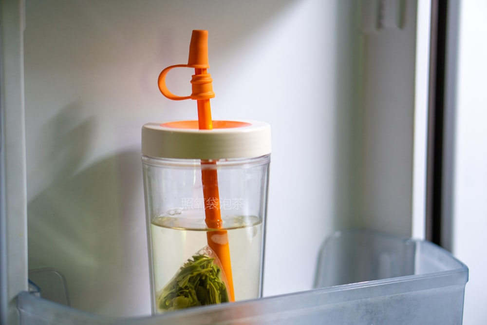 an orange straw sticking out of a cup