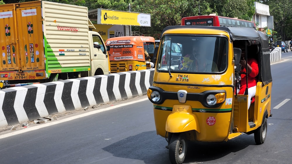 a yellow tuk tuk driving down a street