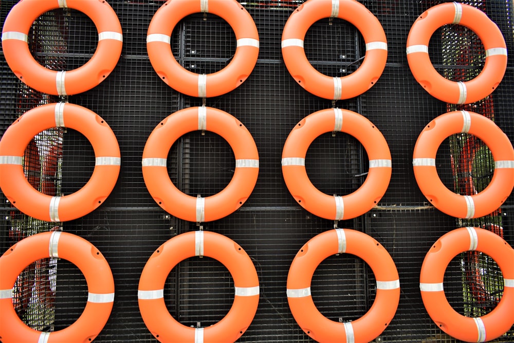 a bunch of orange life preservers sitting on a rack