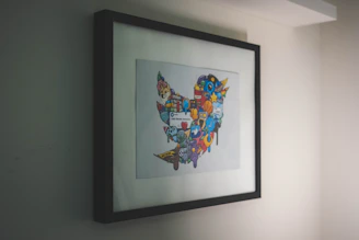 Close-up of a quirky, colorful art print leaning against a vintage frame.