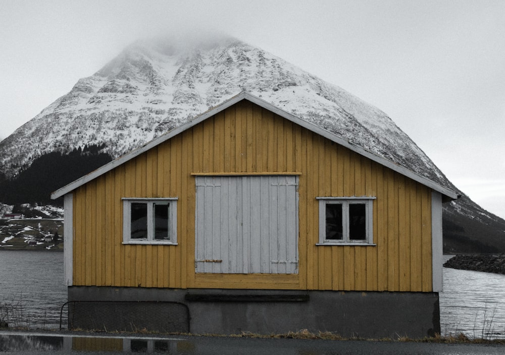 a yellow house with a mountain in the background