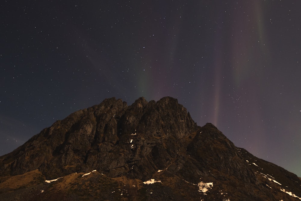 a very tall mountain under a night sky