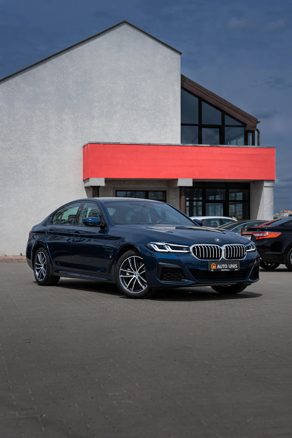 Blue BMW M5 photographed outside a building