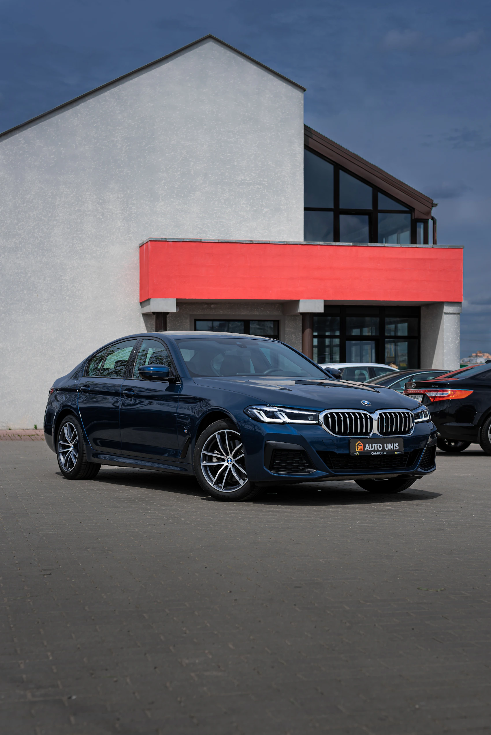 Blue BMW M5 photographed outside a building
