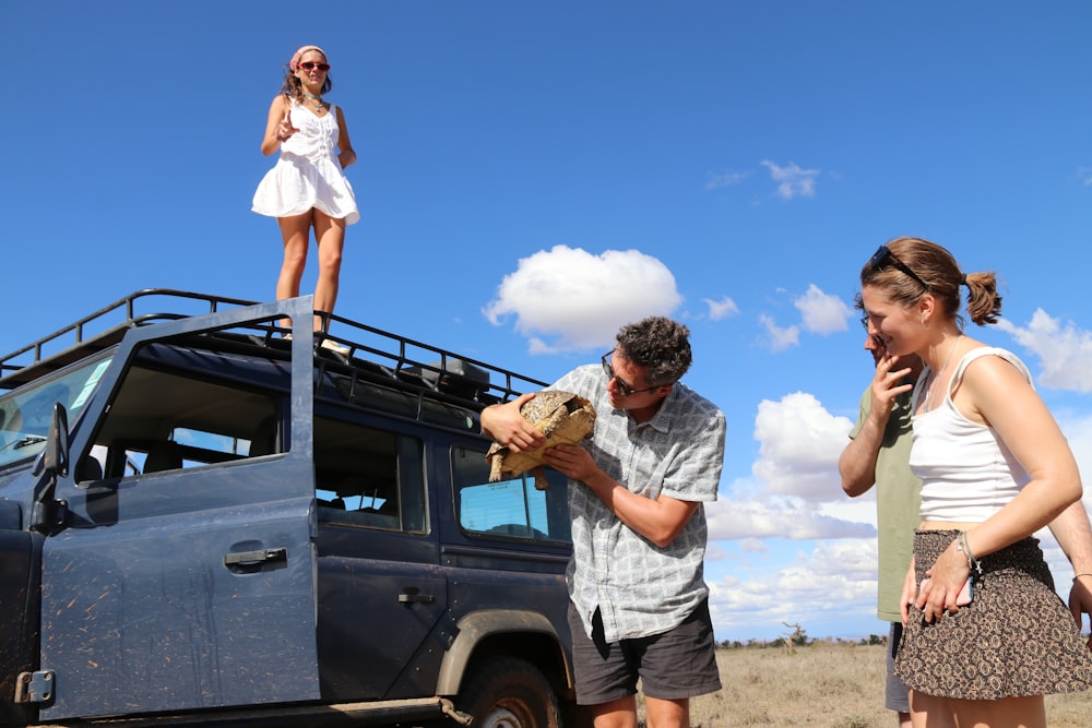 a woman standing on top of a vehicle