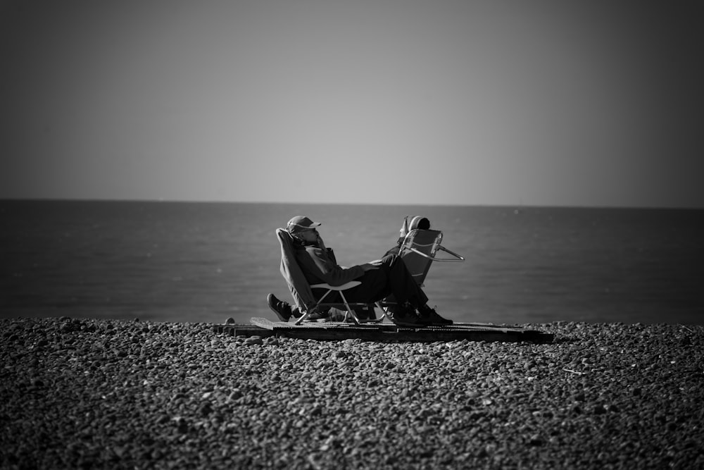 a person sitting on a beach near a body of water