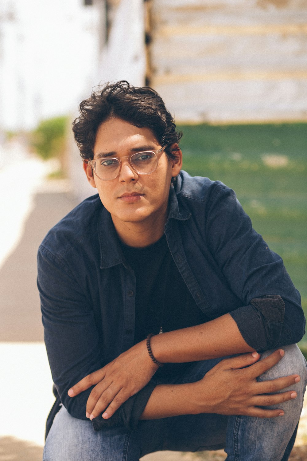 a man with glasses sitting on the ground