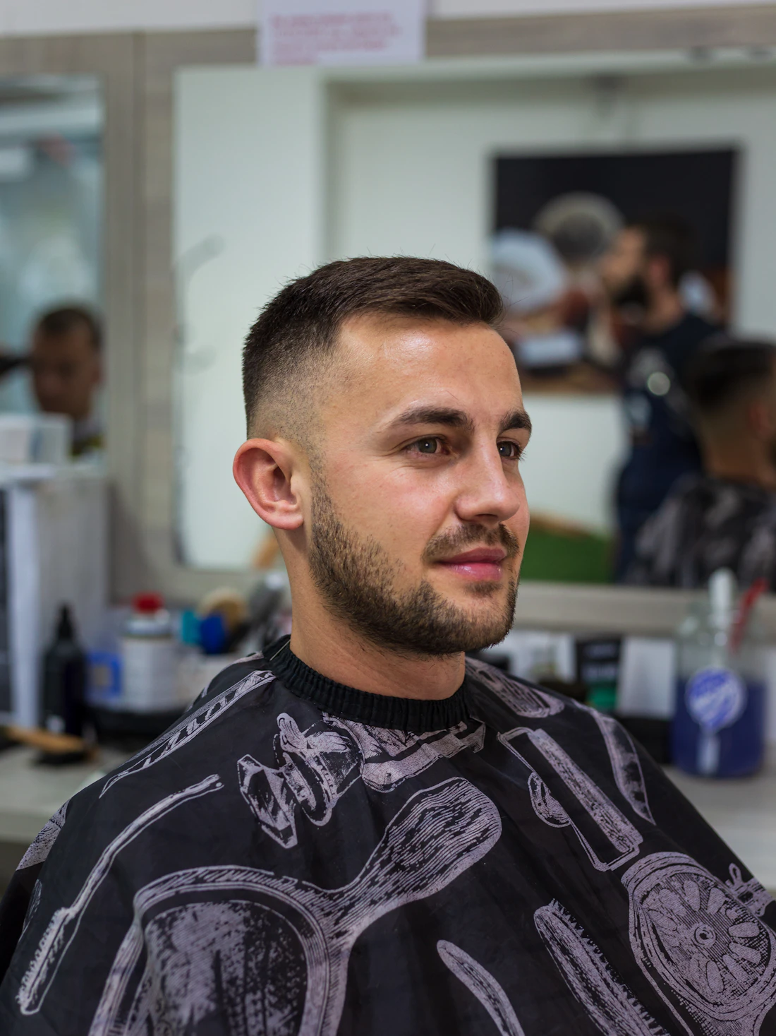 Klient w fotelu podczas strzyżenia fade