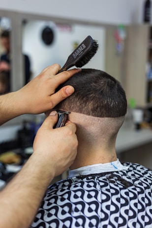 a man getting his hair cut by a barber