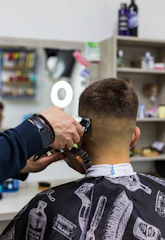 a man getting his hair cut at a barber shop