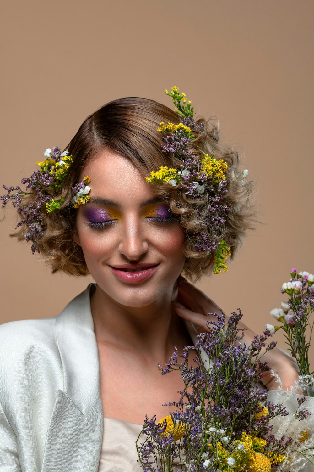 a woman with flowers in her hair holding a bouquet of flowers