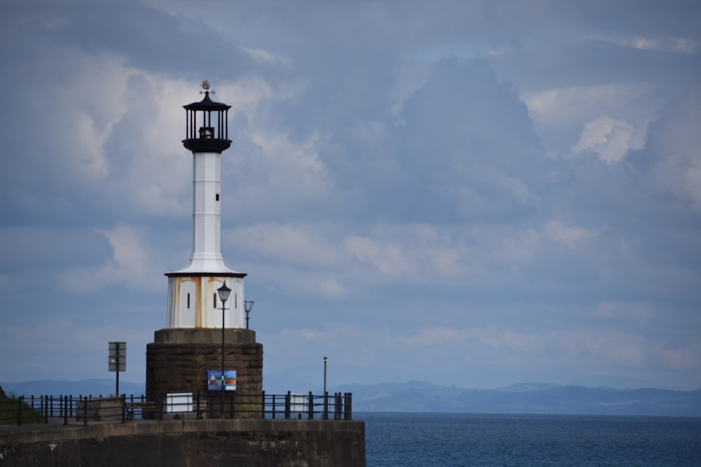 a light house sitting on top of a pier next to the ocean