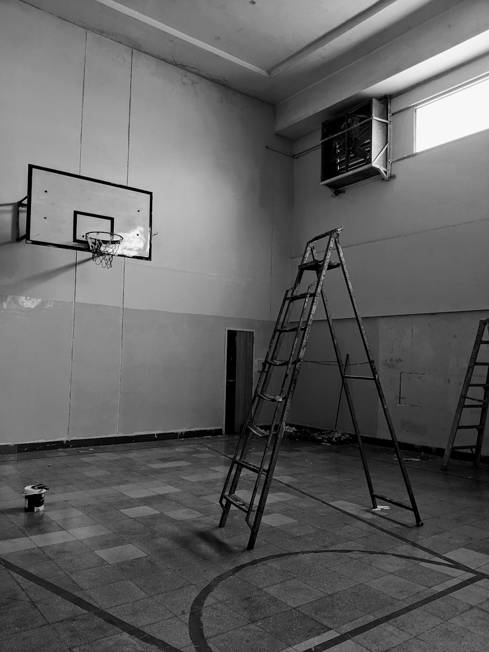 a basketball court with ladders and a basketball hoop