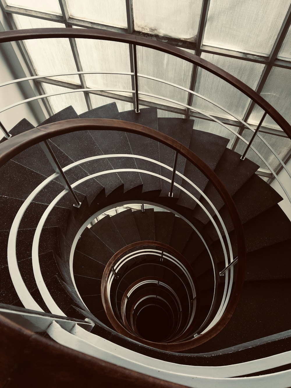 a spiral staircase in a building with glass walls