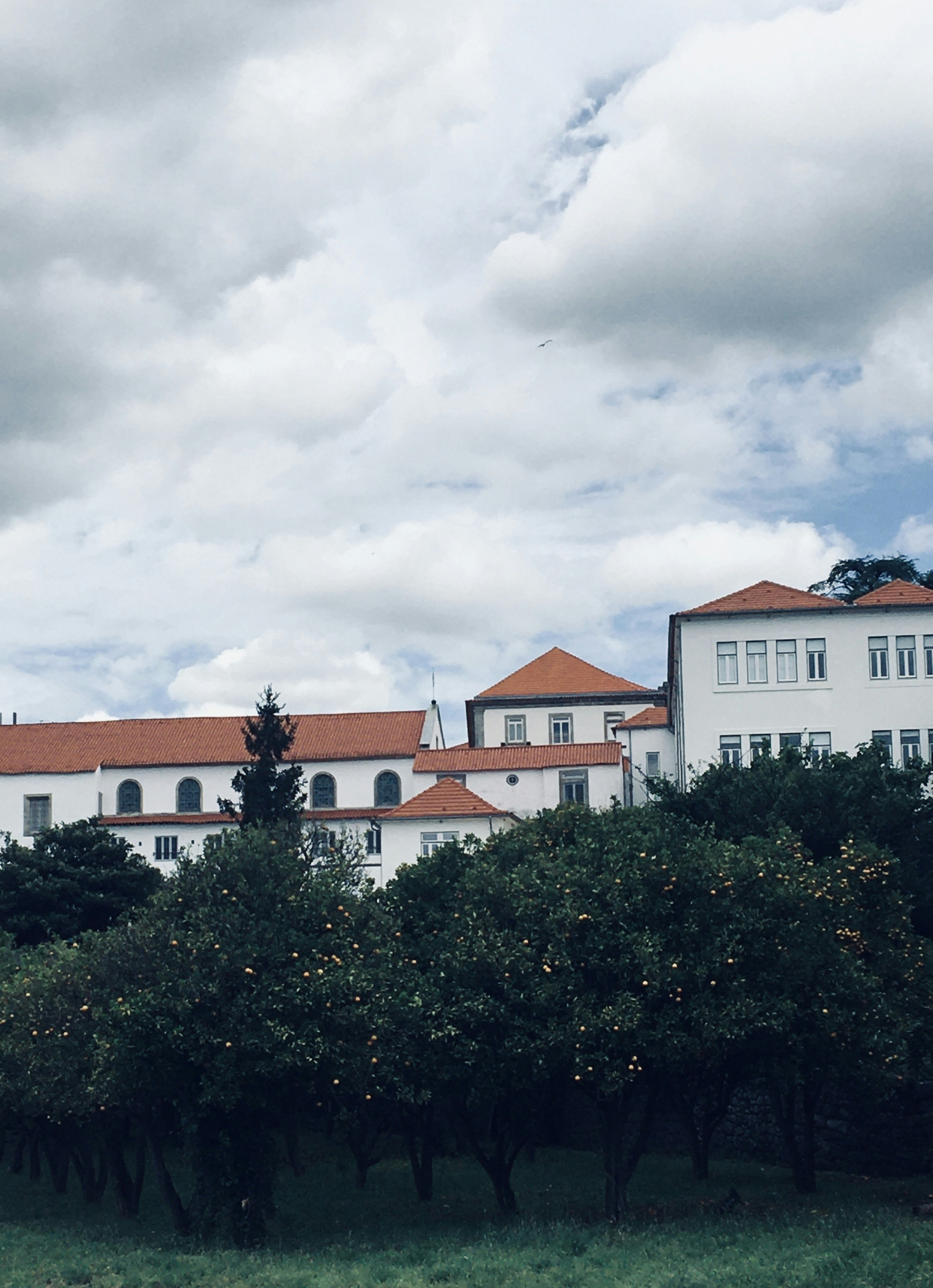 a large white building sitting next to a lush green field