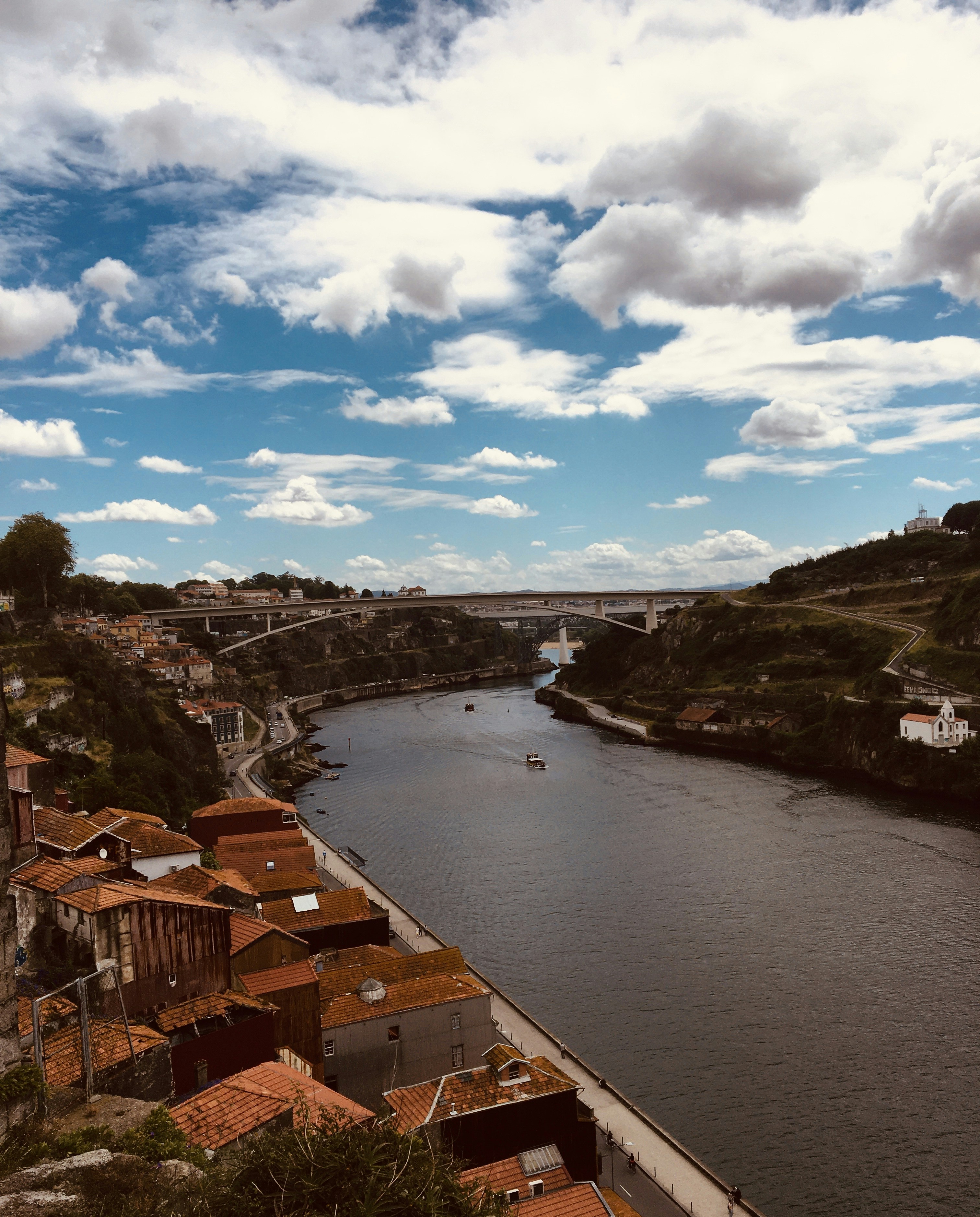 a river running through a small town under a cloudy sky