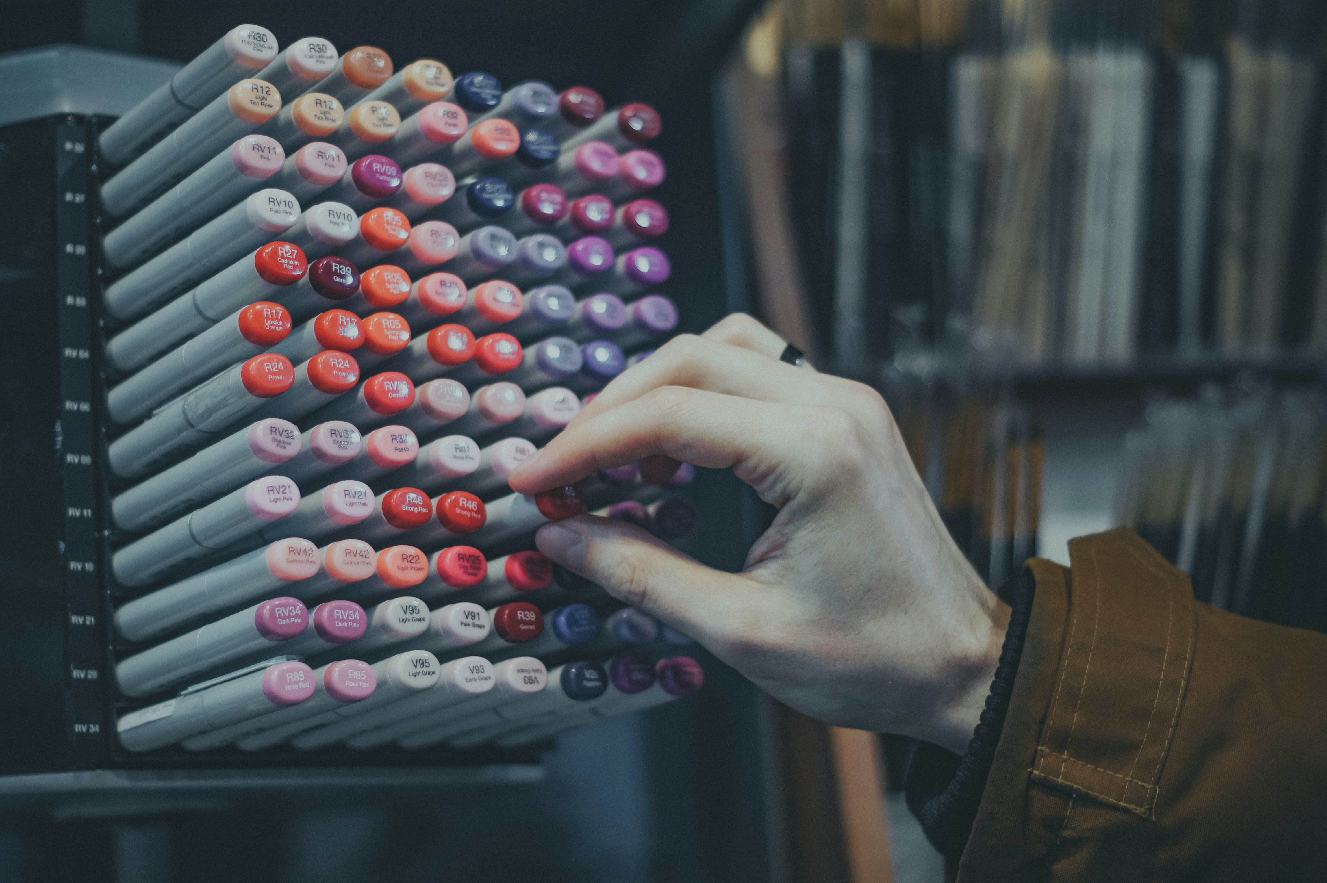 a person is holding a large display of nail polish