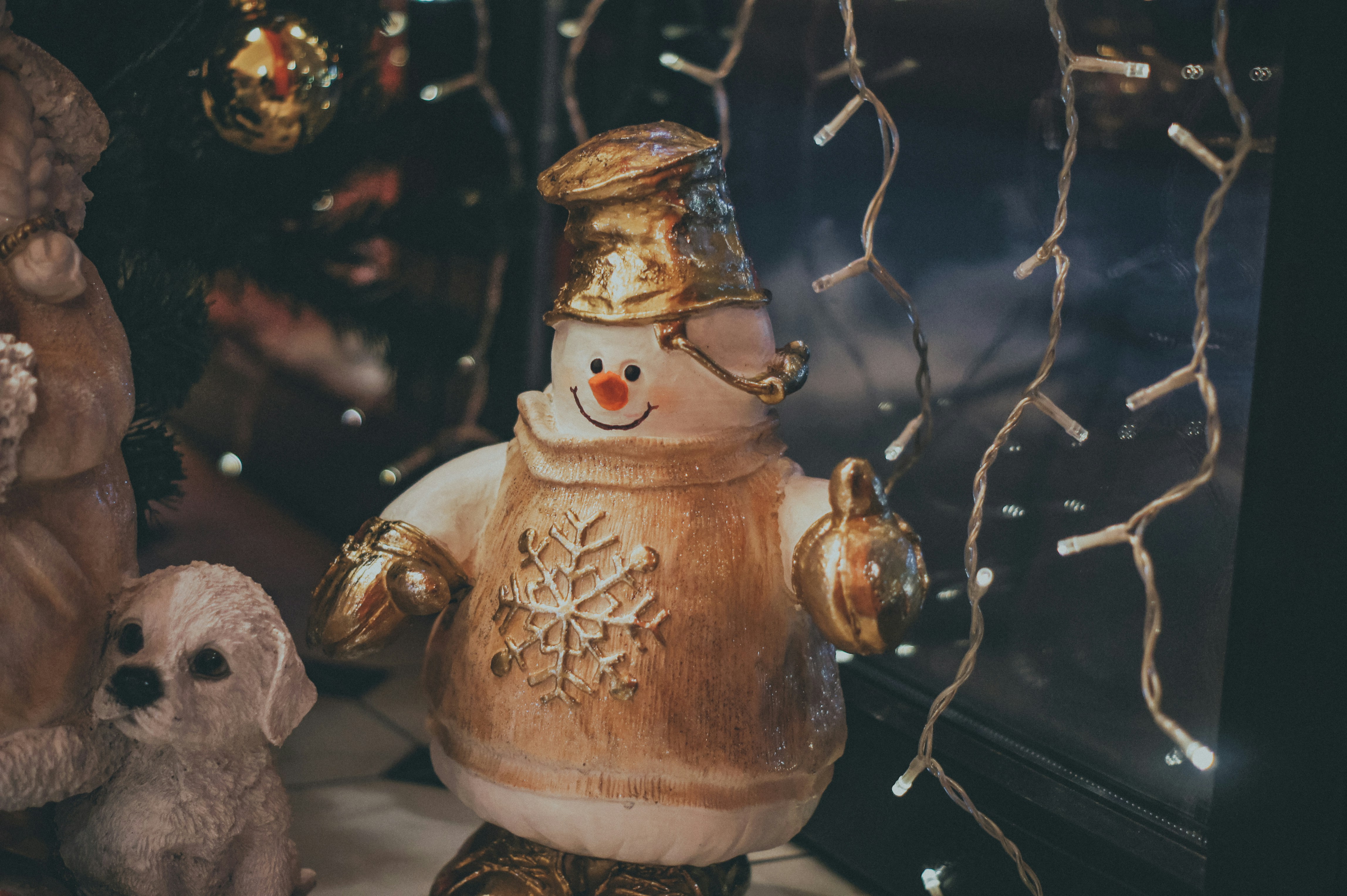 Eine Schneemann-Statue neben einem Weihnachtsbaum