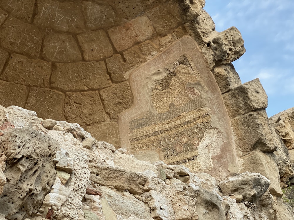 a close up of a stone wall with a sign on it