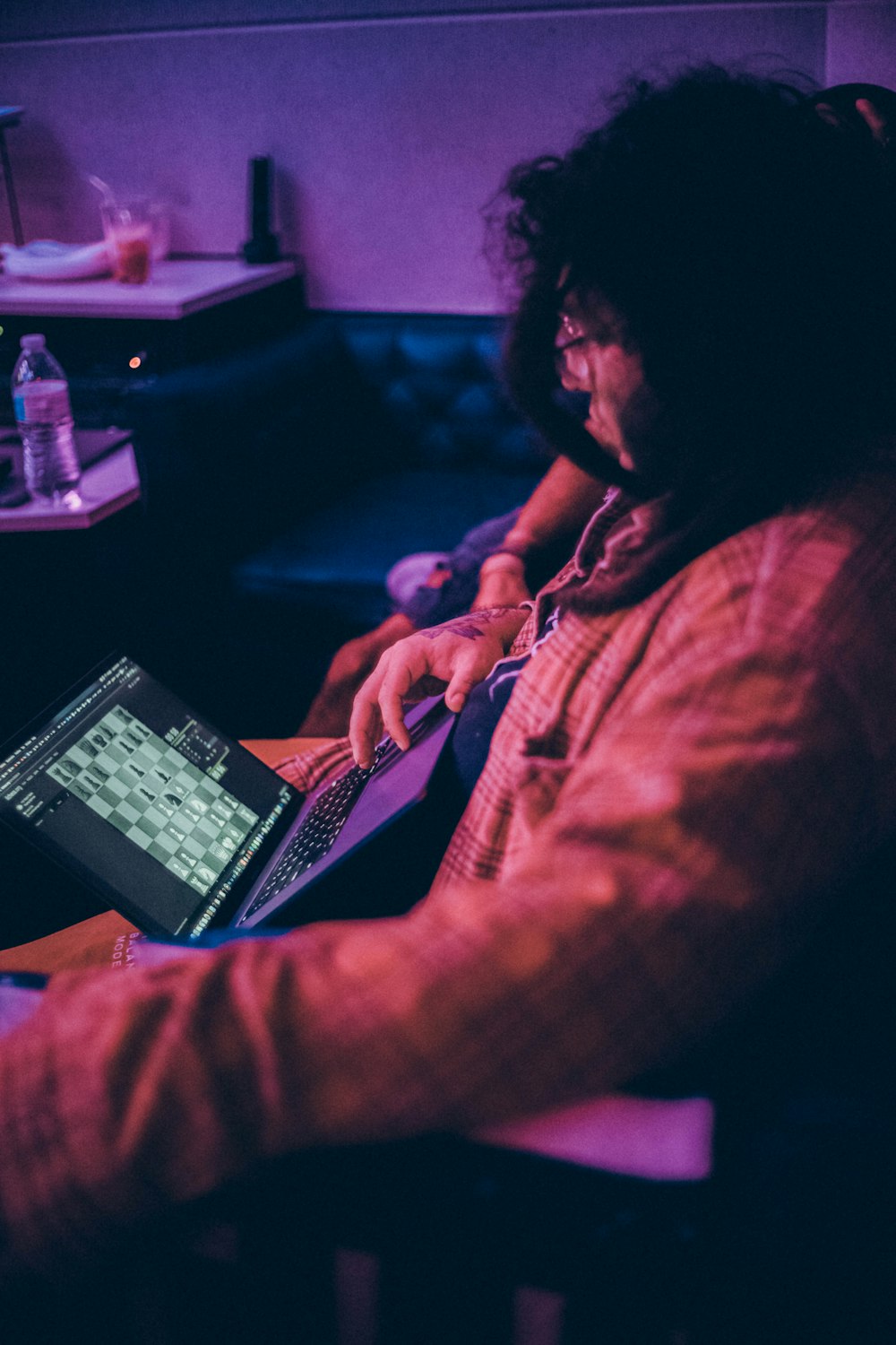 a man sitting in a chair using a laptop computer