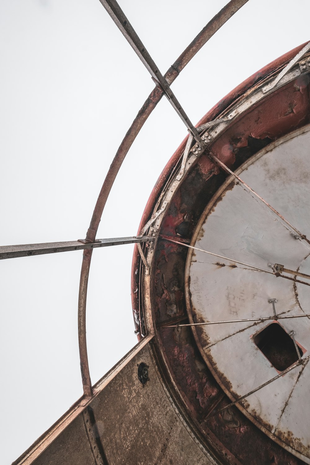 a rusted clock tower with a sky in the background