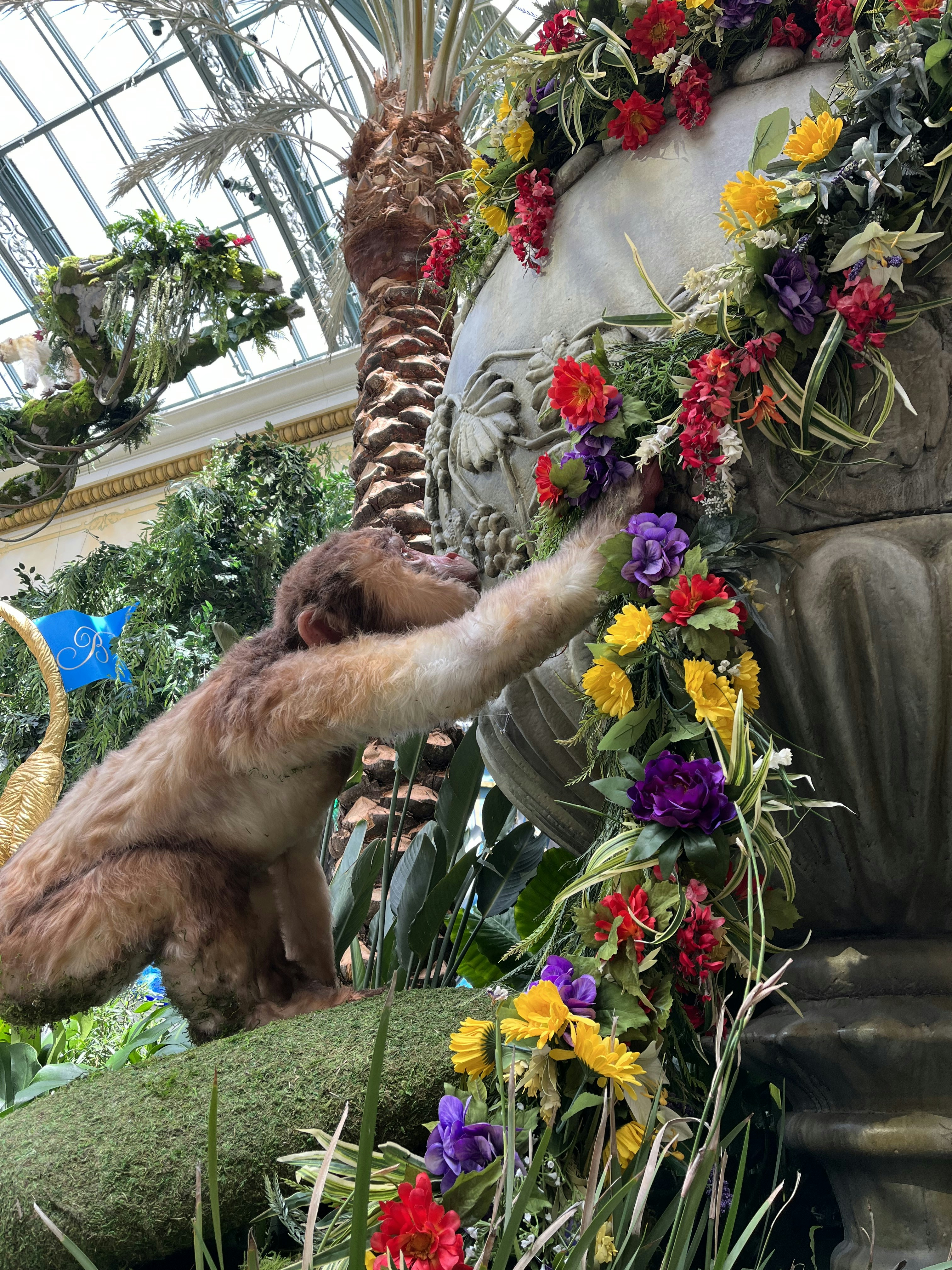 a gorilla climbing up a tree in a garden