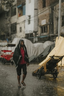 a man walking down a street in the rain