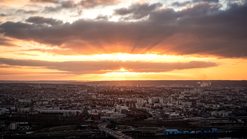 the sun is setting over a city in the distance