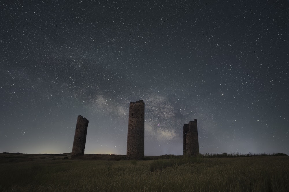 a group of pillars sitting on top of a grass covered field