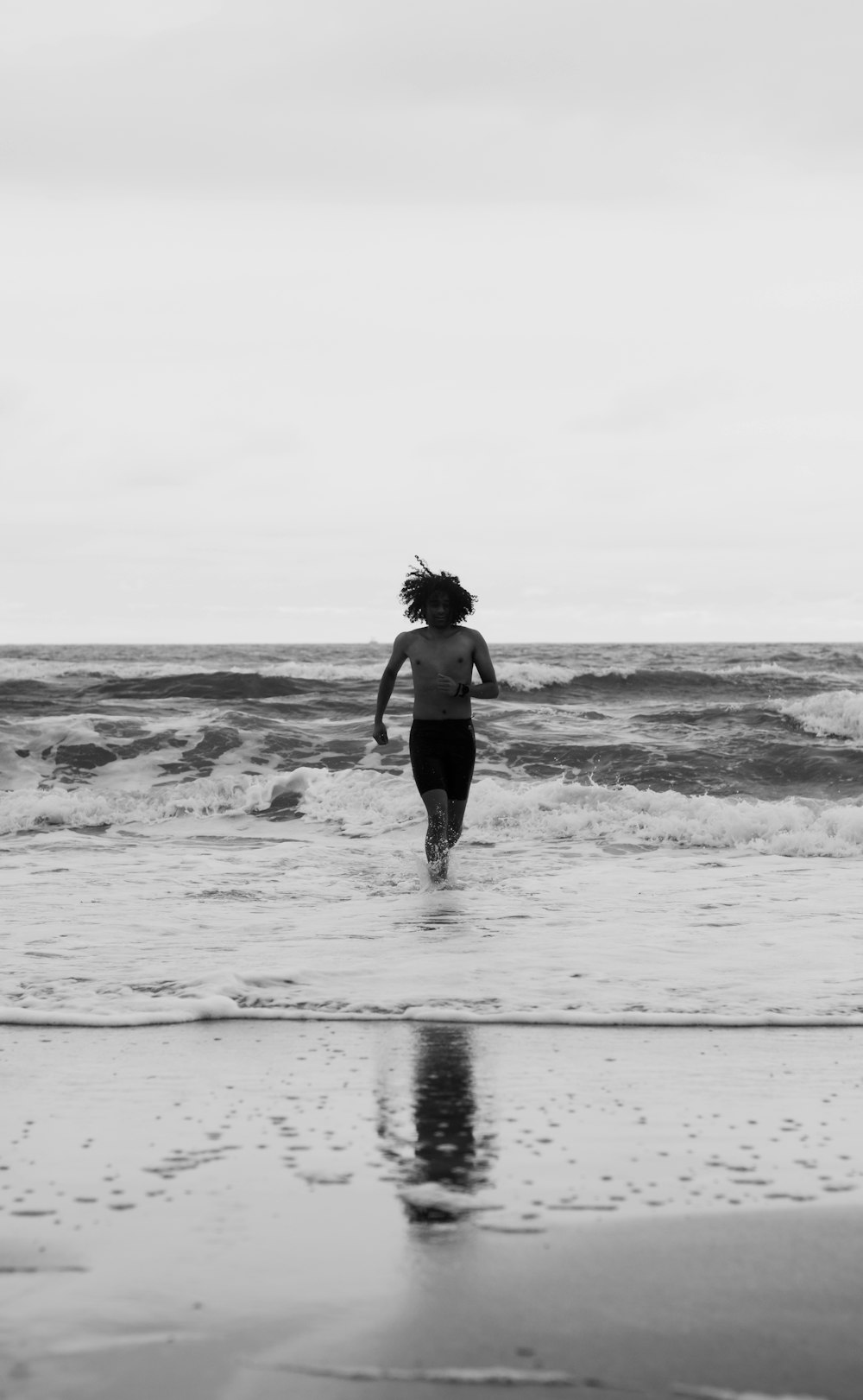 Una persona corriendo hacia el océano en una playa