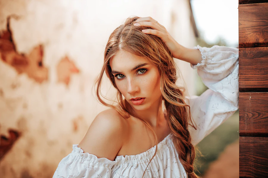 a woman with long hair wearing a white top