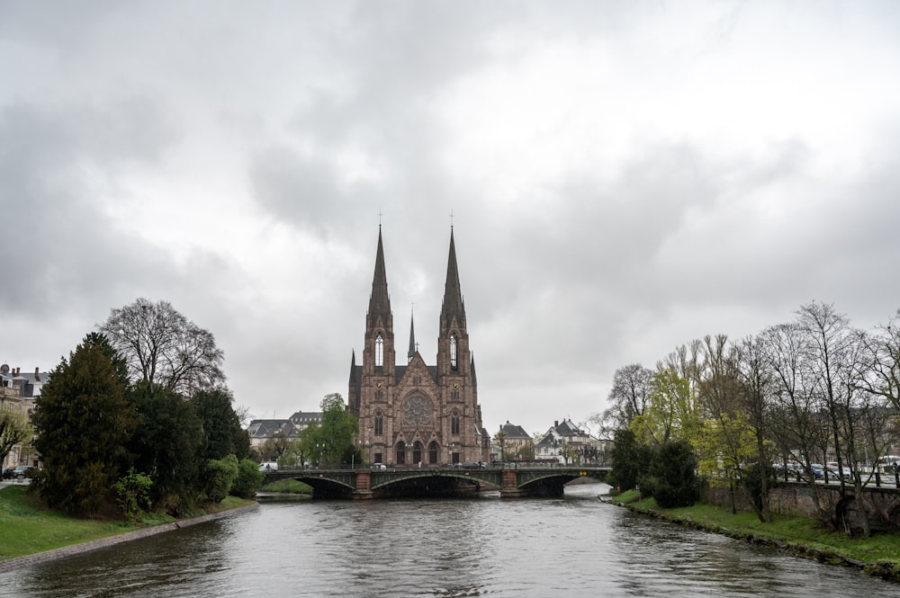 a large cathedral towering over a river next to a bridge