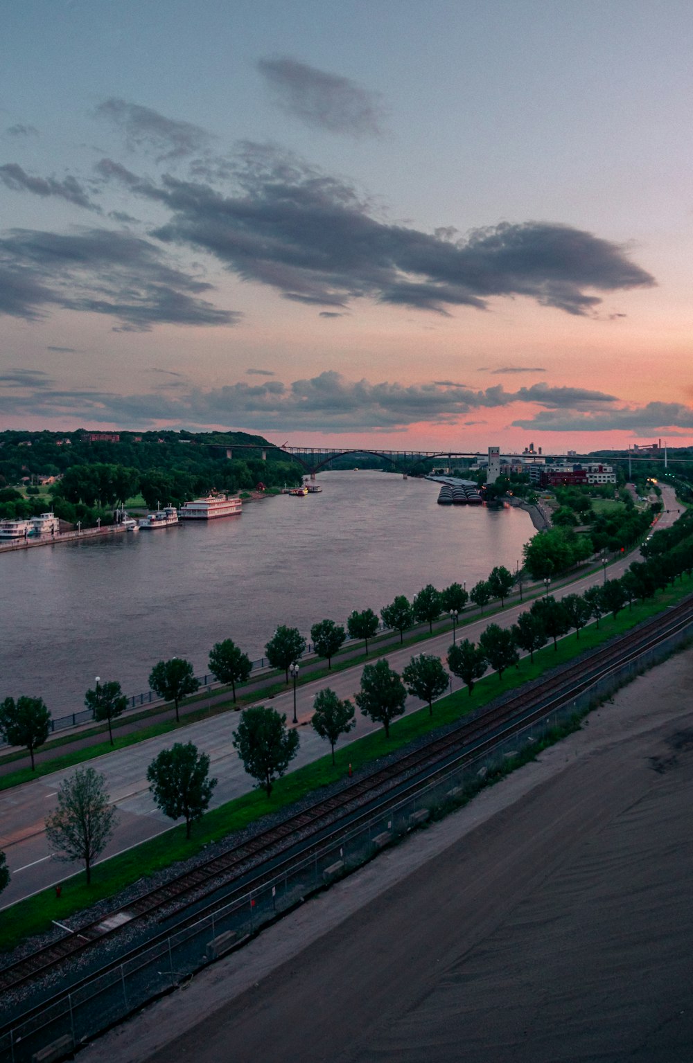 a view of a river and a train track at sunset