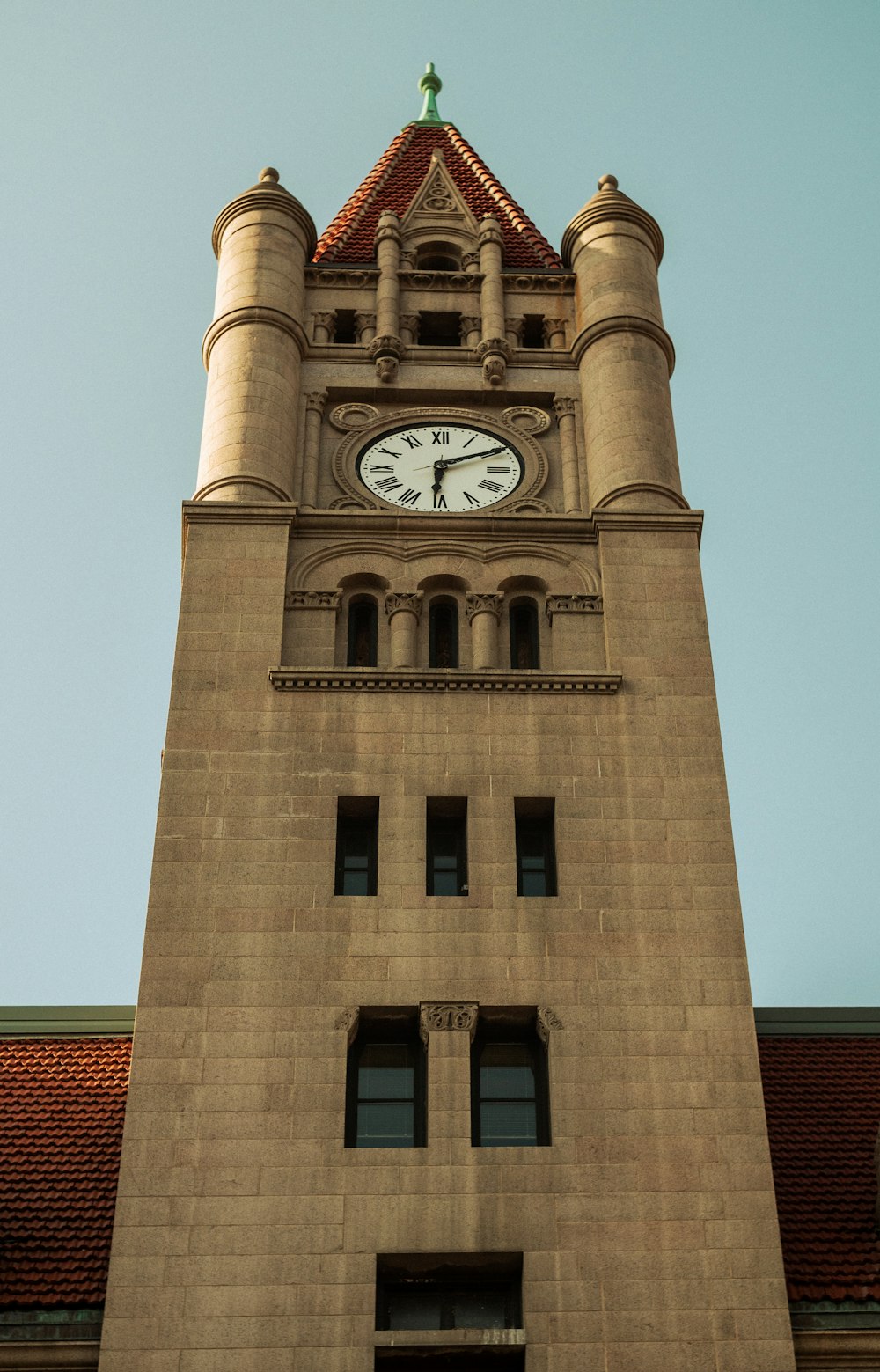 ein hoher Glockenturm mit einer Uhr an jeder Seite