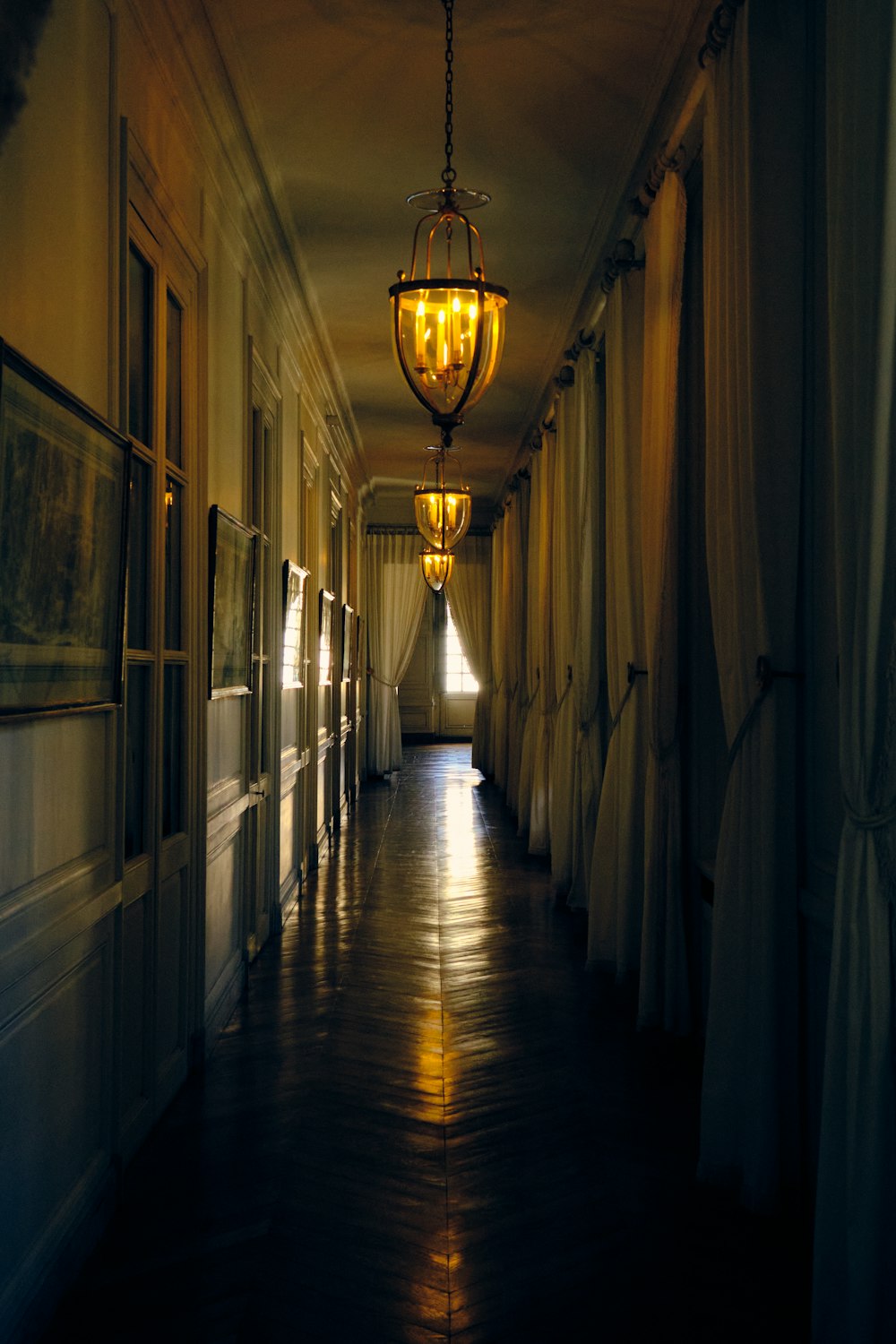 天井から光がぶら下がっている長い廊下