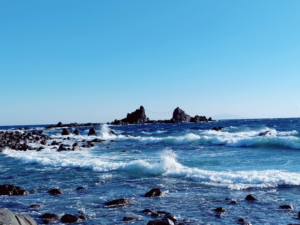 a body of water with rocks in the background