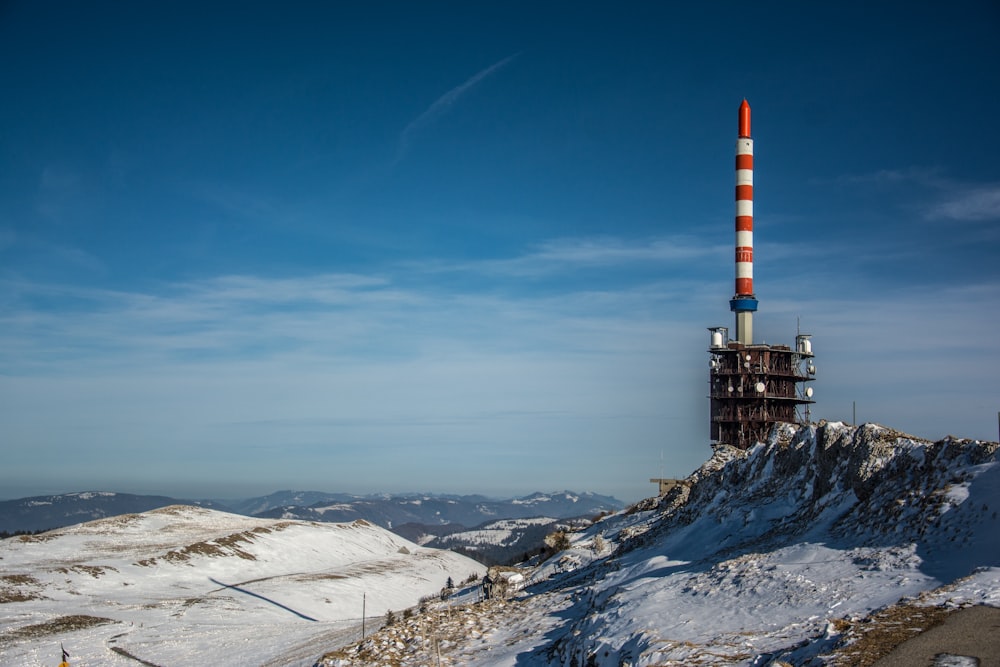 a very tall tower on top of a snowy hill