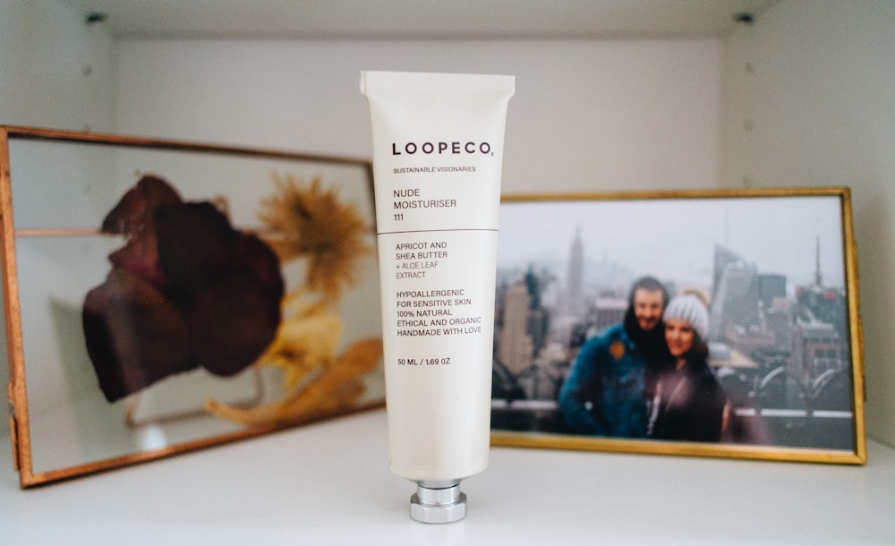 a tube of lotion next to a picture of a man and woman