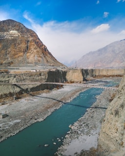 a river running through a valley surrounded by mountains