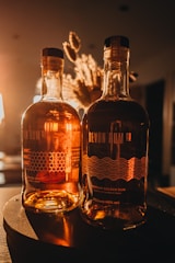 Elegant bottles of rich, dark rum displayed on a vintage shelf with tropical accents.