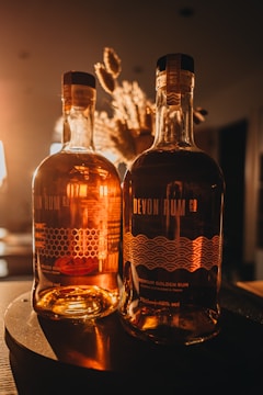 Elegant bottles of rich, dark rum displayed on a vintage shelf with tropical accents.