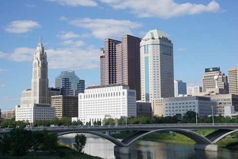 a bridge over a river with a city in the background