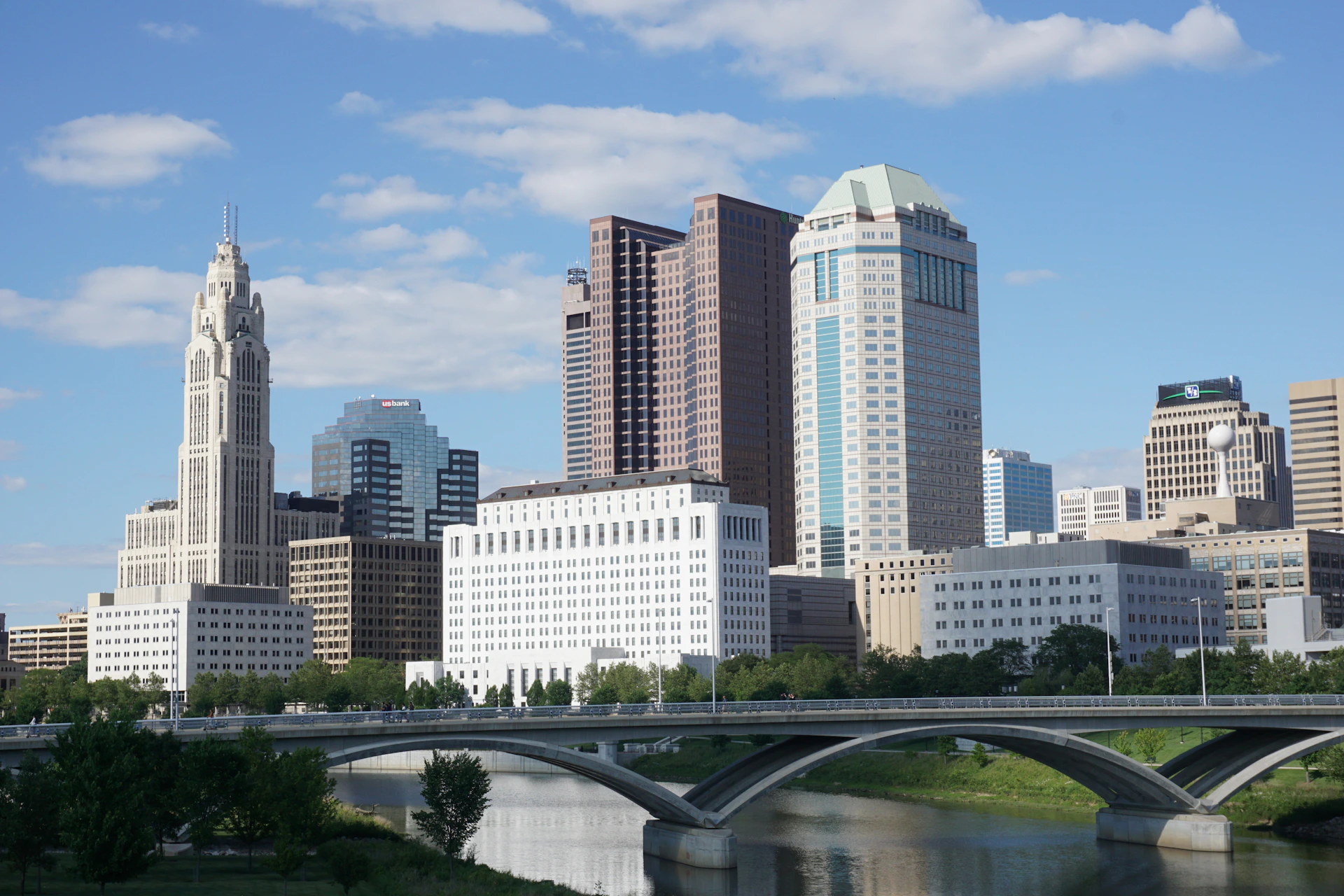 a bridge over a river with a city in the background