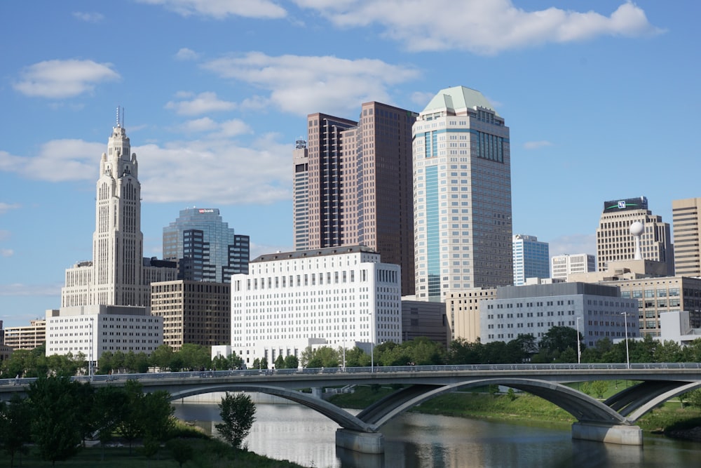 a bridge over a river with a city in the background