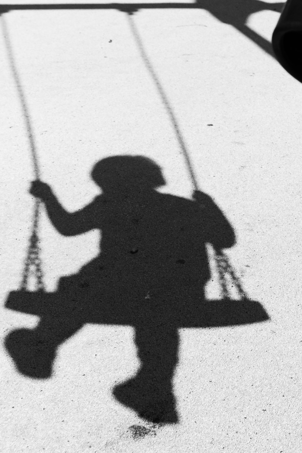 a shadow of a child on a swing