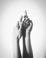 A sleek black and white photograph of intertwined hands.