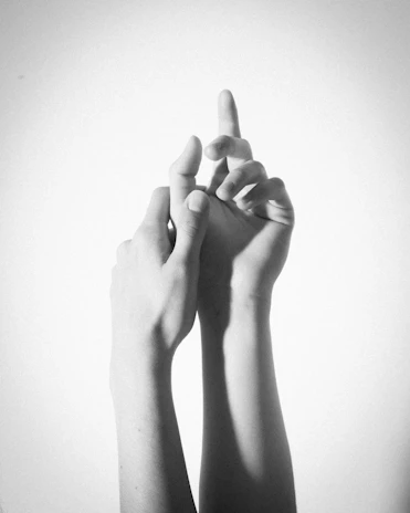 An intimate black and white photo of hands intertwined, telling a quiet story.