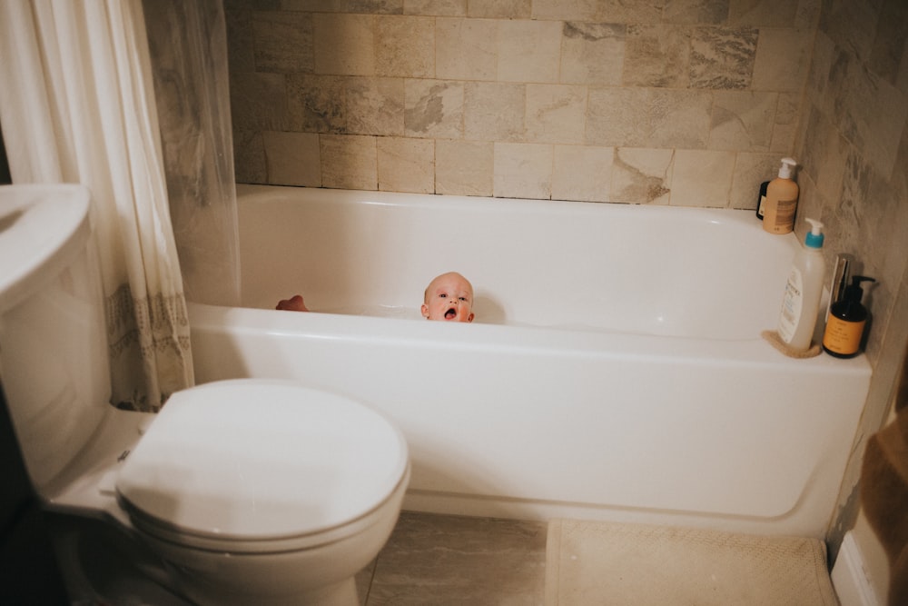a baby is sitting in a bathtub in a bathroom