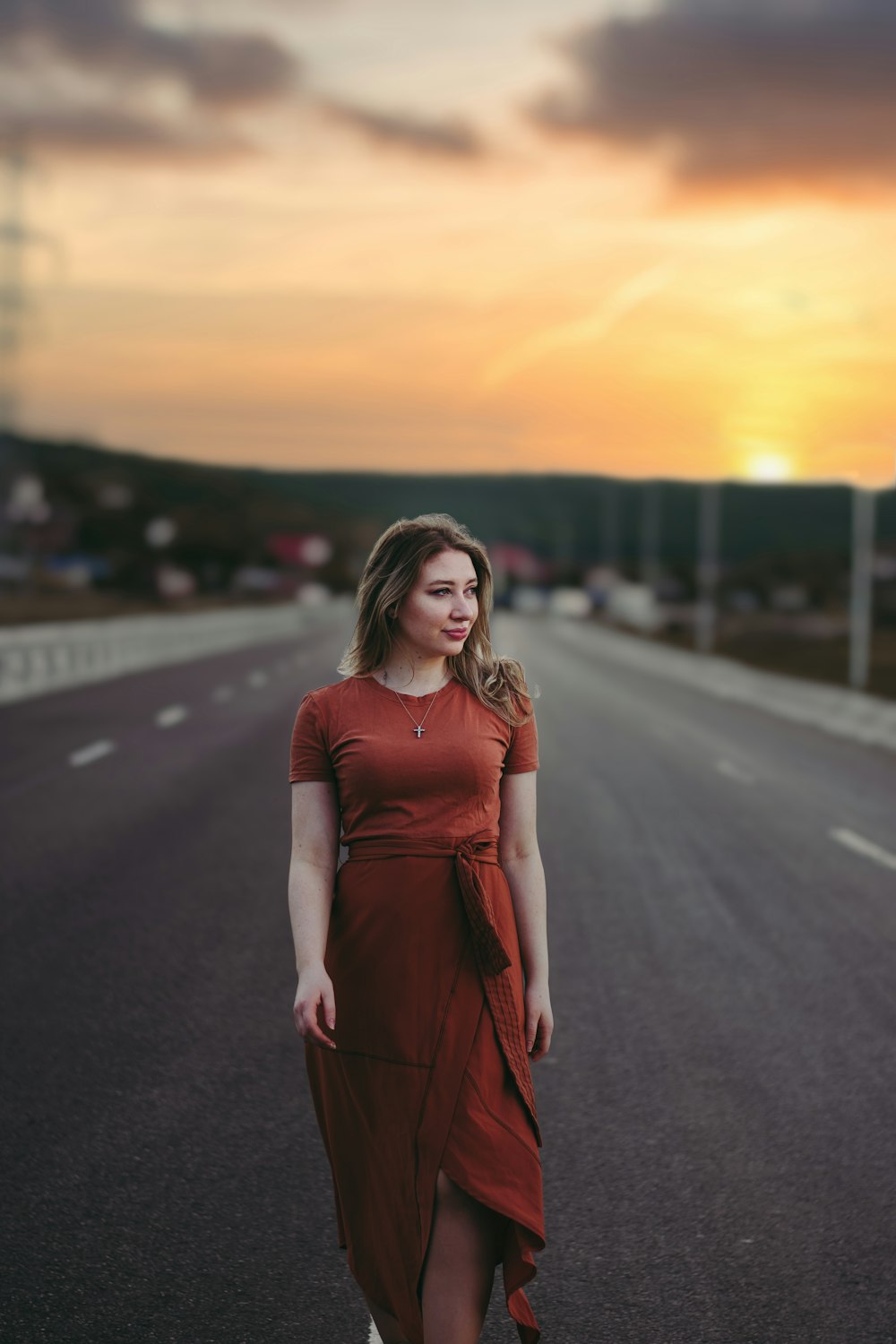 a woman standing on the side of a road